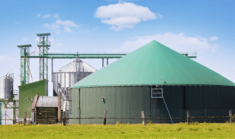 Planta de biometano en zona rural, realizada con material de color verde y metálico.